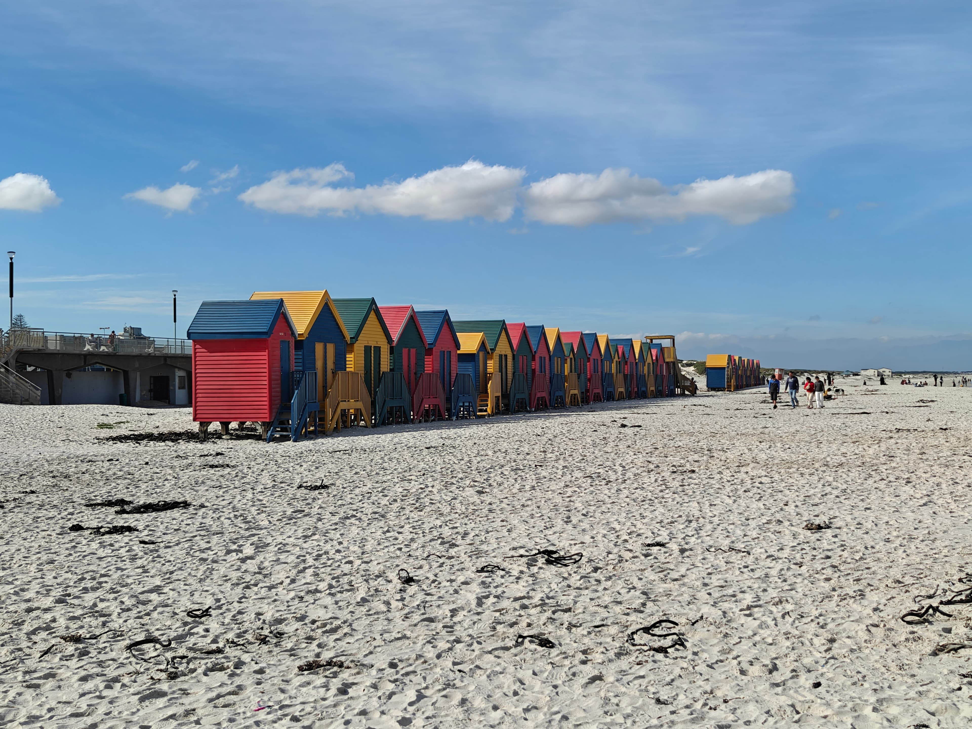 Row of brightly painted Victorian bathing boxes on Muizenberg Beach at Surfer's Corner, Cape Town