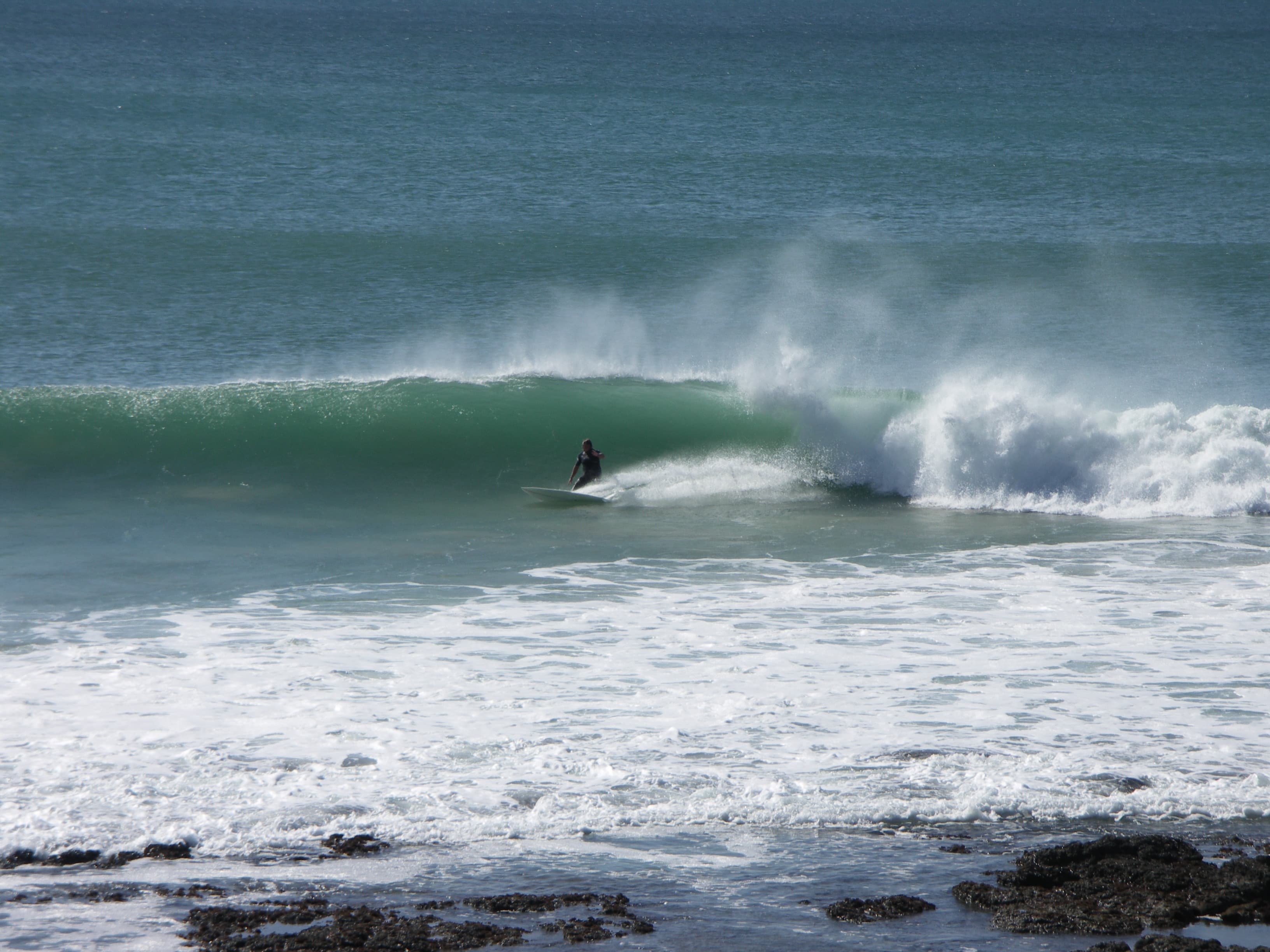 Surfer riding the Supertubes point break at Jeffreys Bay, a renowned surf spot on the Eastern Cape coast